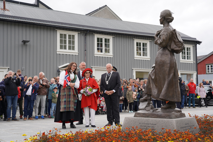 Under byvandringen stoppet Dronningen ved statuen av Astrid Langjord (1885-1956). Hun var sentral i arbeidet med å samle draktmaterialet fra vefsnområdet som Nordlandsbunaden er basert på.  